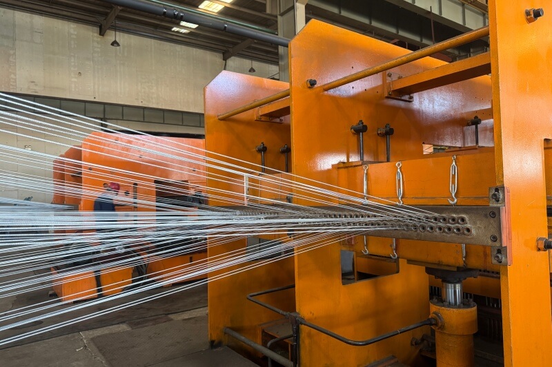 Steel cord tensioning and alignment process for conveyor belt reinforcement