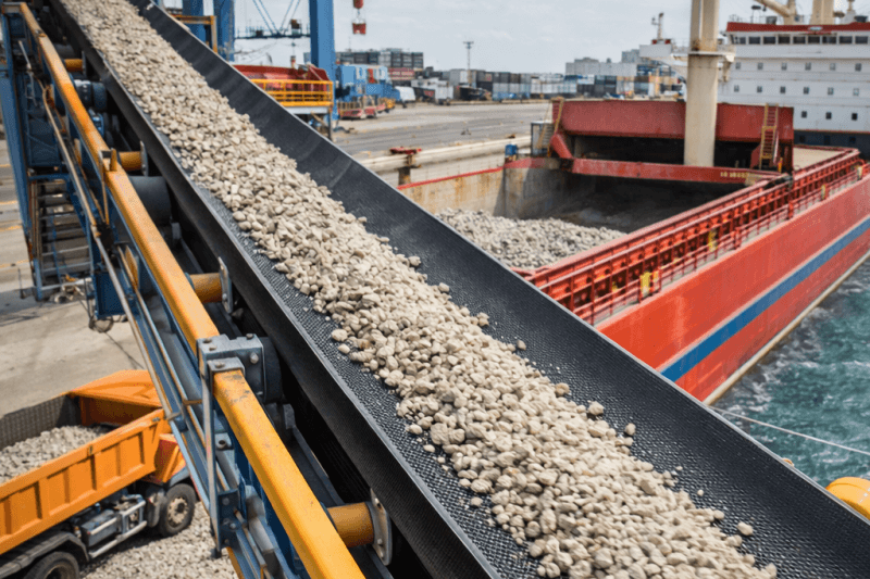 Heavy-duty conveyor belt transporting bulk aggregates at port loading terminal