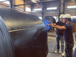 Vietnam customer inspecting finished conveyor belt during factory visit
