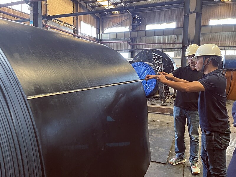 Vietnam customer inspecting finished conveyor belt during factory visit