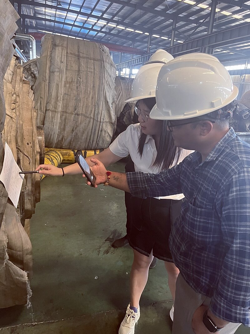 Indian customer checking conveyor belt specifications and documents during factory visit