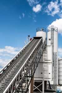 Chevron patterned rubber conveyor belt in inclined conveying application at industrial plant