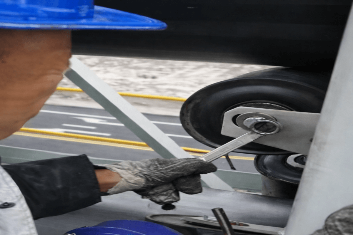 Technician adjusting idler roller system for pipe conveyor belt installation and maintenance