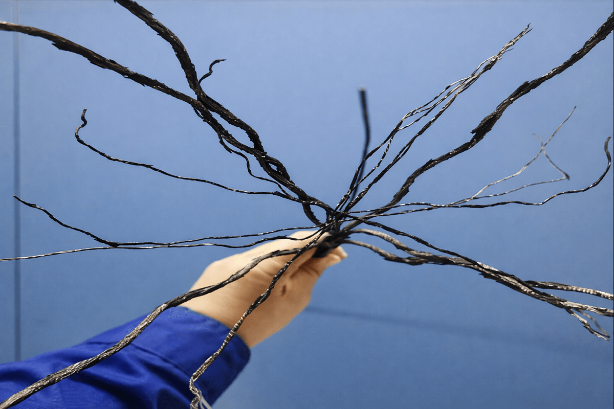 Burned steel cord reinforcement from damaged pipe conveyor belt showing thermal and electrical failure details