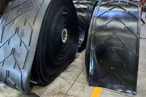 Industrial rubber chevron conveyor belt roll with V-pattern cleats for inclined bulk material handling systems